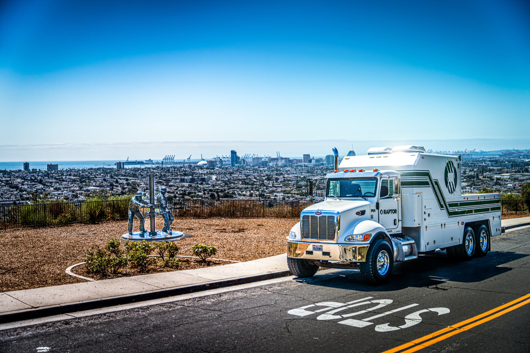 Raptor truck on a coastal road with the city skyline